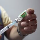 Profissional manipula seringa com vacina contra Covid 19