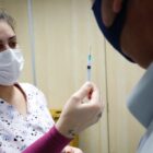Enfermeira mostra vacina sendo preparada para paciente que vai receber o imunizante