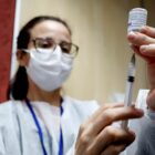 Profissional da saúde prepara a vacina para aplicação