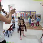 Crianças brincam com professora em sala de aula da educação infantil