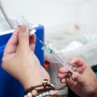 Profissional de saúde manipula seringa com vacina