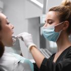 Dentista examina boca de paciente