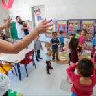 Professora com alunos crianças em sala de aula de centro de educação infantil