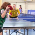Duas atletas de tênis de mesa disputam partida