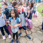 Crianças uniformizadas chegam em escola