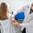 Enfermeira aplica vacina contra a dengue em adolescente menina