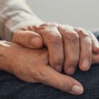 mão de uma pessoa idosa segura gentilmente a mão de outra pessoa idosa