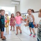 Crianças dançam e pulam em sala de aula de Centro de Educação Infantil