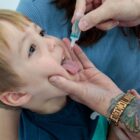 Menino abre a boca para ser vacinado
