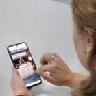 Mulher acessa a Plataforma Visite Joinville Virtual pelo celular